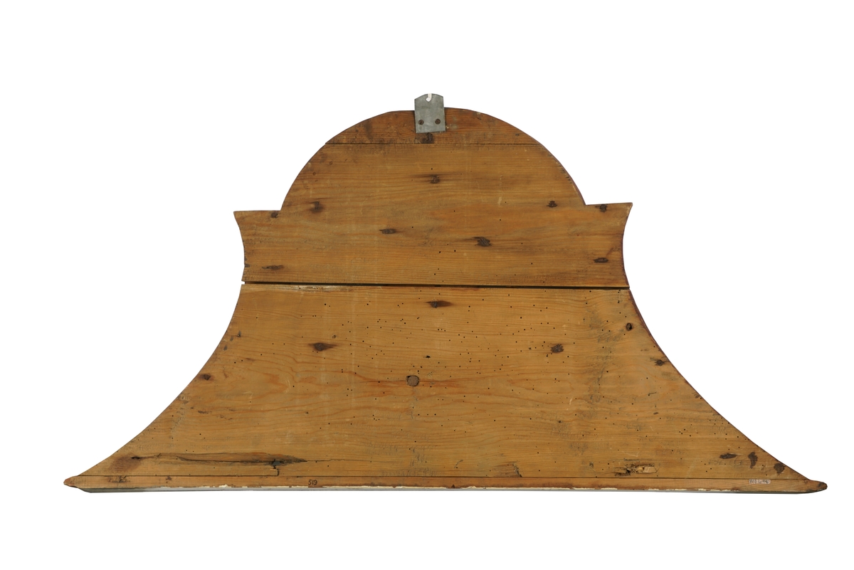 Døroverstykke bestående av 3 sammensatte trebord med not og fjær (bunnplaten). Det har en trekantet hovedform med rett underkant, innadbuede sider og utadbuet overkant. Bunnplaten er utskåret og i flere nyanser av blått, påsatt 2 forhøyninger. Den øverste er oval, blåmalt med krone i gull og rødt over "CR" påmalt i brunt, og langs kanten en lysutskåret bord. Den nederste er formet som en girlander og er avlang, buet og blåmalt med "Told-inspekteurens  Contoir" påmalt med brunfarge. Langs kanten er det en lysutskåret bord og på hver side en lys, utskåret dusk. Skiltet omgitt av en rett list i underkant samt en rød og grå buet, profilert list på sidene og i overkant. Disse er malt i noe som minner om en marmoreringsteknikk (bemalt imitasjon av marmor).Tilhører et sett med tre døroverstykker .Jfr. B-bok nr. 518,519,520. Nr. 518 er borte (ToldCassererens Contoir") Antatt fra Christiania iht. B-bok