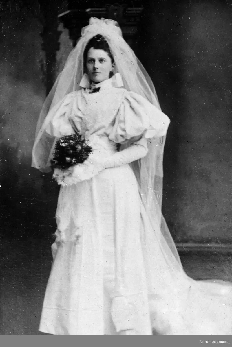 Dette er Anna Dorothea Heyerdahl f. 1874 Kristiansund. Hun var datteren til Niels Roth Heyerdahl og kone Anna Dorthea. Anna Dorothea ble gift i 1895 med Johan Andreas Hveding f. 1863 Kr.sund. 

Dette brudebildet er altså fra 1895, noe man også ser på de store "skinkeermene" på brudekjolen - som var mote i 1890-årene.
(ifo: Randi Elisabeth Hagen)  -
Brudefoto. Giver er Ida M. Knudtzon. Fra Nordmøre museums fotosamlinger.