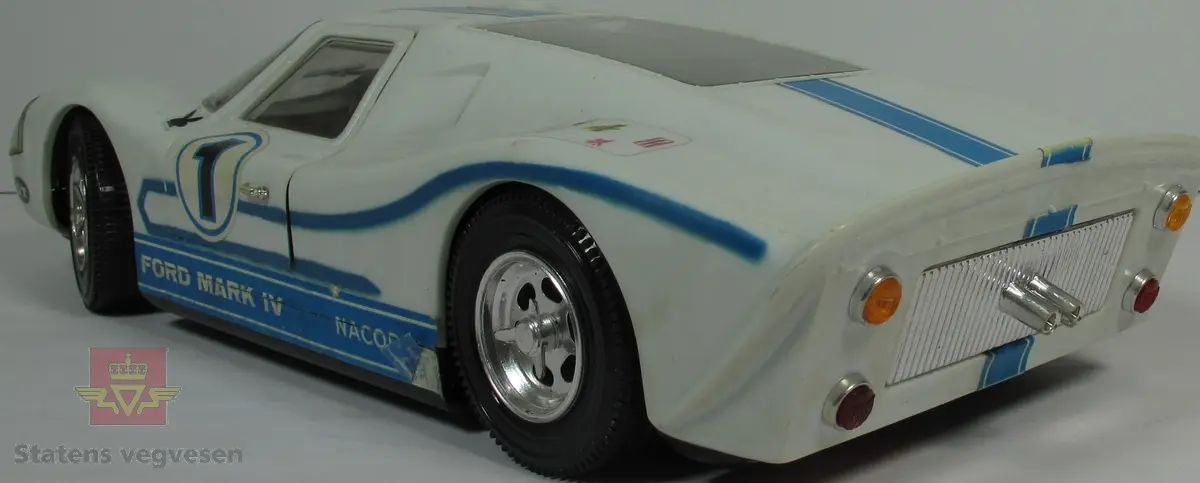 Miniatyr, lekebil i papp. Farge grønn og svart, med bilde av bilen. Bilen har hovedsakelig fargen blå overalt, men har tallet 1 på overflaten foran kjøreren, og en svart stripe fra panser til bakenden. Skala 1:12