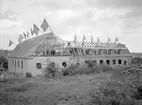 Soldathemmet till Första och Andra livgrenadjärregementena i Linköping under uppförande. Dagen till ära firas taklagsfest. Byggnaden stod klar 1925, uppförd efter ritningar av Axel Brunskog. Lågdelen kommer efter färdigställande att tjäna som sällskapsrum, kafé m.m. Den tvärställda byggnadsdelen kommer att inrymma ett kyrkorum.