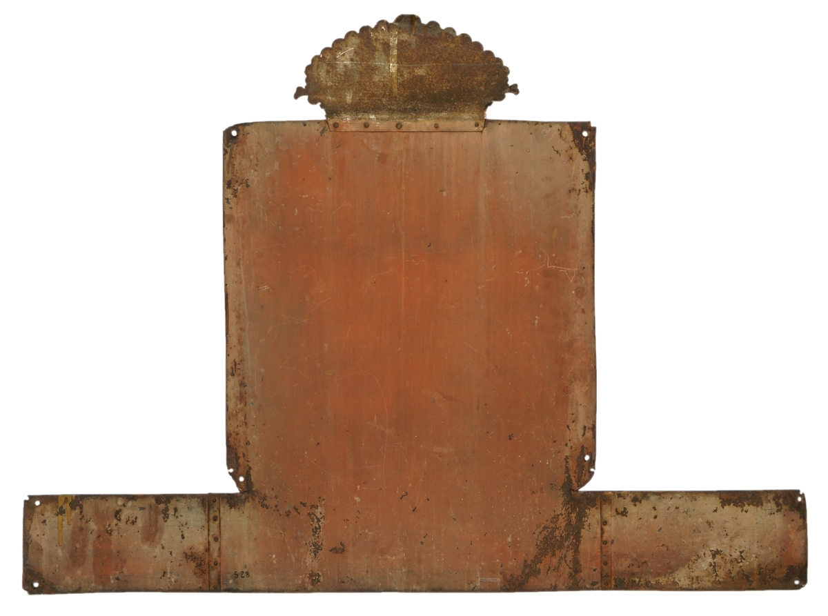 Firkantet metallskilt, rødbrunt med krone i gull og rødt over løve i gull med øks. Rikseplet med Olavskorset mangler på kronen. "Braarud Toldstation" er  skrevet i gull på blå, firkantet bunn. Kronen er festet på hovedskiltet ved bruk av popnagler. Skiltet er forlenget/bredde nederst ved popnagler på endestykker på hver side av skiltet. Hull i alle hjørner fot antatt oppheng.