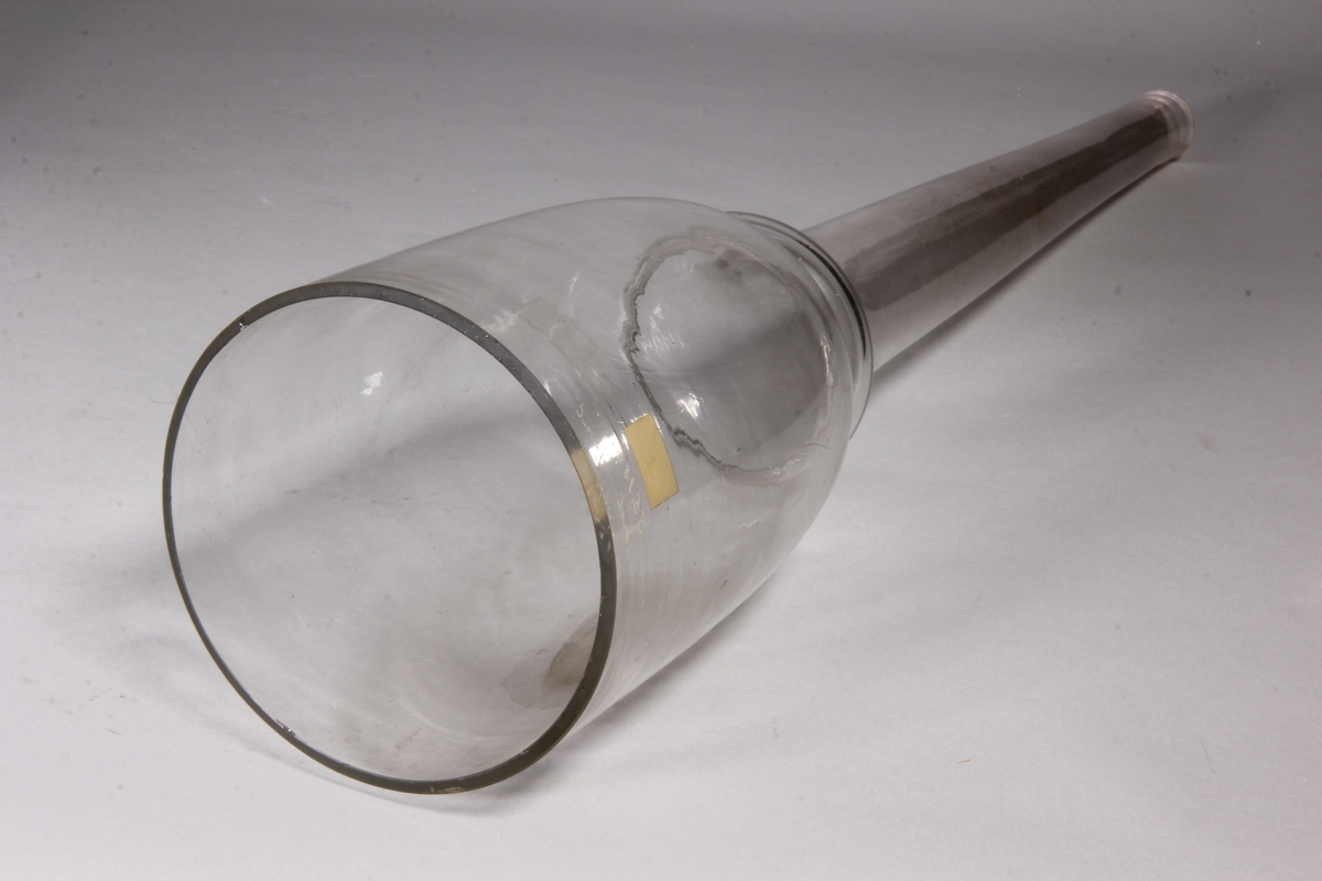 Trattrör av klart glas. Cylindrisk överdel som avslutas med vulst som övergår i långt rör.