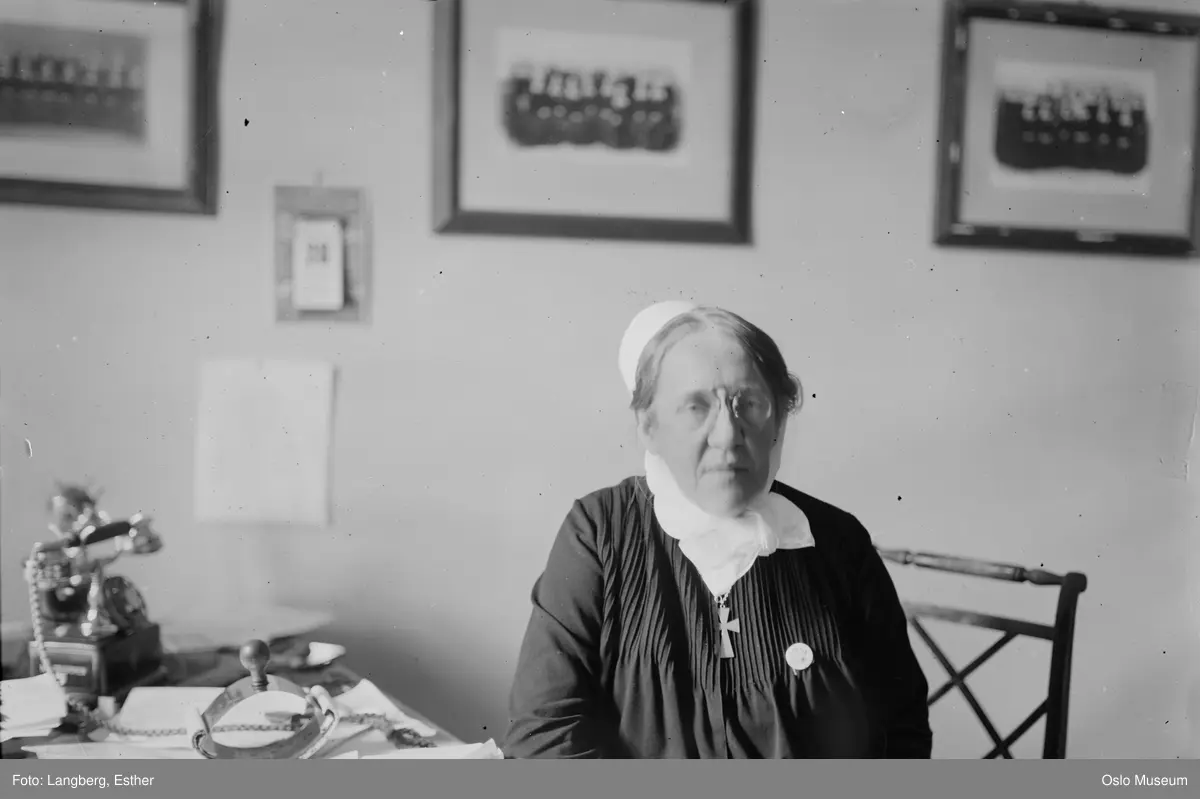 kvinne, diakonisse, sittende halvfigur ved skrivebord