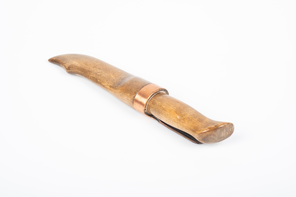 Håndlaget tollekniv med skaft og slire av tre, og knivblad av metall. Skaften og sliren er lakkert med blank lakk. Sliren er pyntet med kobberkant. Fra kobberkanten henger en svart skinnlapp med hull i til oppheng. Bolsteret er av messing.
