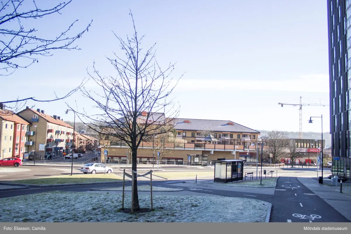 Vy från Storgatan mot Brogatan, år 2015. Till höger skymtas höghuset på Storgatan 32A. Platsen där den vänstra "Mölndals Centrum"-skylten står, blev senare Ulla Jacobssons Plats. Bild 4: till vänster ses Bergmansgatan. Dokumentation av platsen innan rivning och nybyggnation.