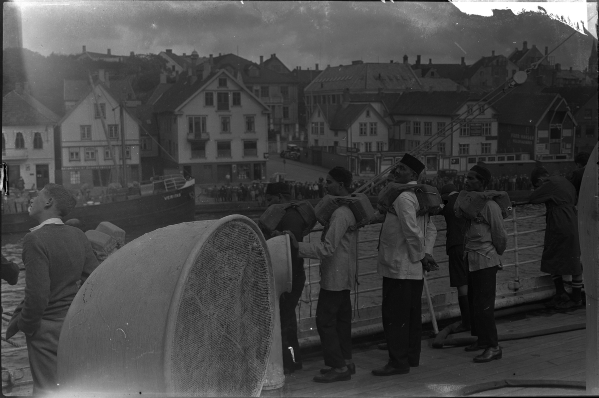Mannskapet på "D/S Neuralia" er stilt opp for fotografen. Det også bilder tatt fra skipet av Vågen i Stavanger. Et bilde er av et korps med sekkepiper og trommer.