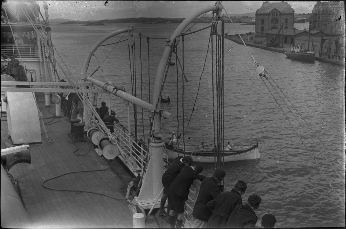 Mannskapet på "D/S Neuralia" er stilt opp for fotografen. Det også bilder tatt fra skipet av Vågen i Stavanger. Et bilde er av et korps med sekkepiper og trommer.