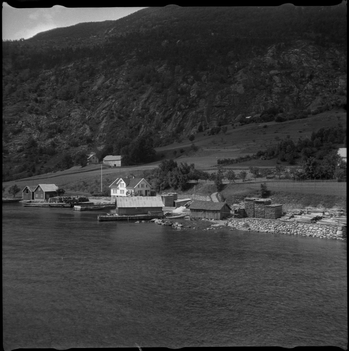 Bilder av familien Skjold fra Sauda i en hage og Oddvar Skjold som gutt på tur ved flere hytter og jettegryter i fjellet.