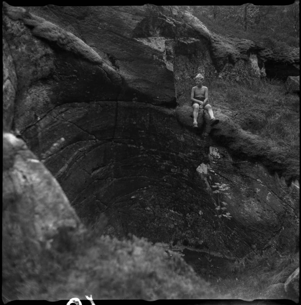Bilder av familien Skjold fra Sauda i en hage og Oddvar Skjold som gutt på tur ved flere hytter og jettegryter i fjellet.
