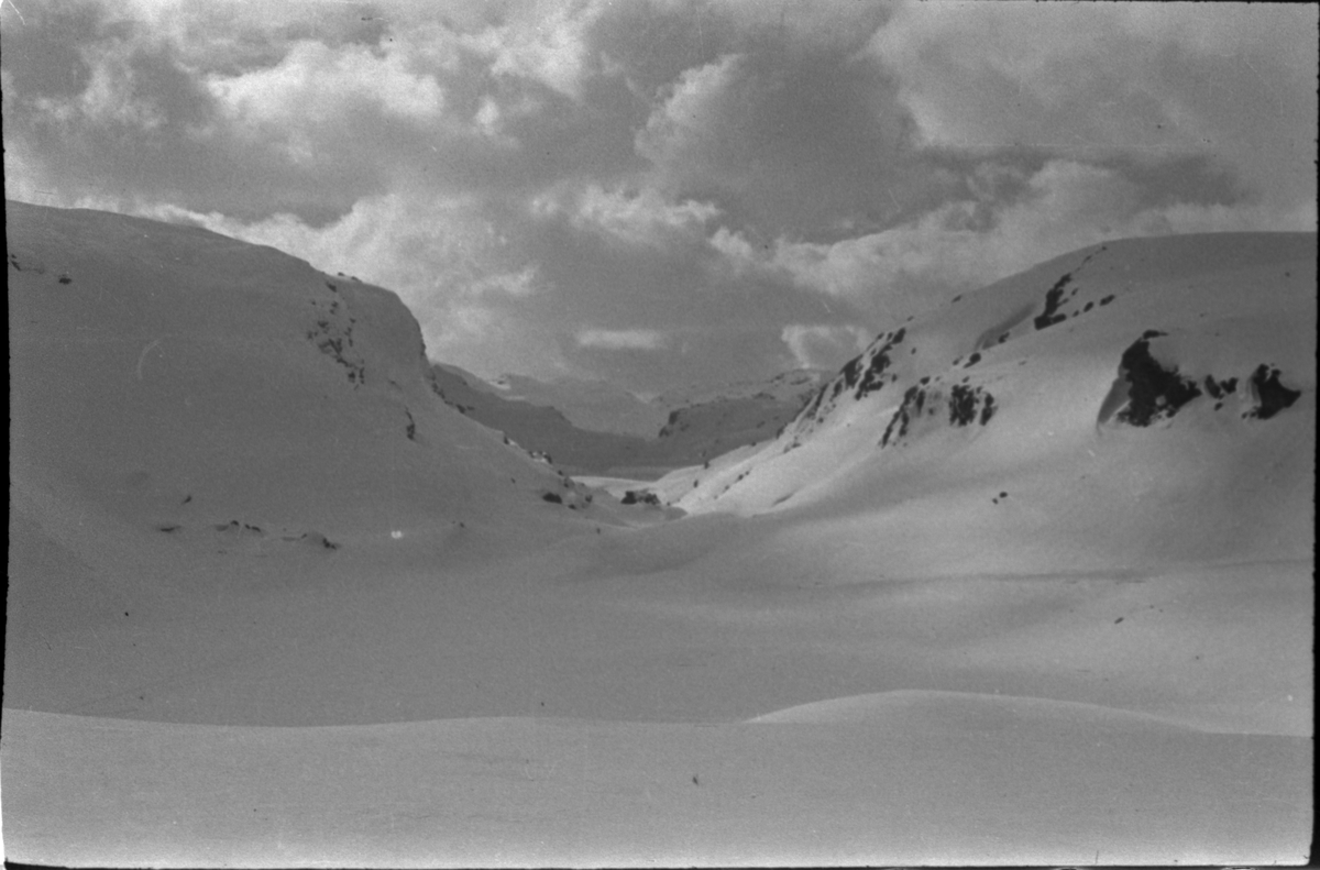 Bilder fra en påskeskitur til Stranddalen turisthytte i Suldal. Det er bilder av landskapet med turgåere, av folk som smører ski utenfor turisthytta og av et stort turfølge som tar pause i snøen.