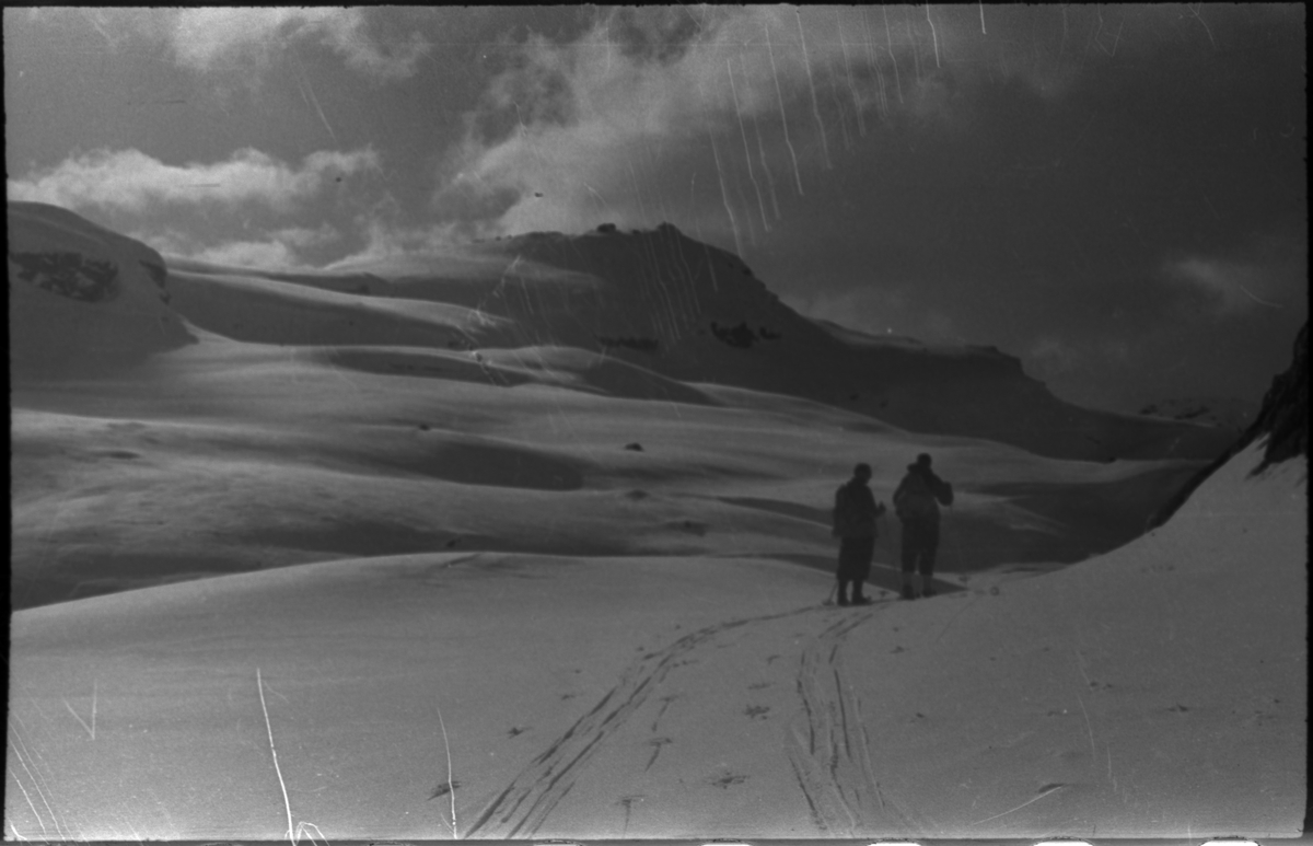 Bilder fra en påskeskitur til Stranddalen turisthytte i Suldal. Det er bilder av landskapet med turgåere, av folk som smører ski utenfor turisthytta og av et stort turfølge som tar pause i snøen.