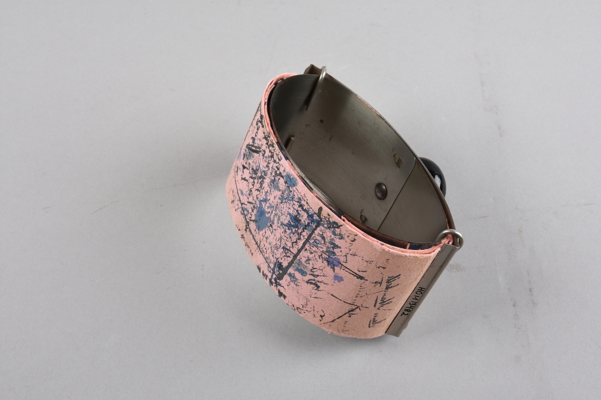 Haldar for trekkpapir. Eit flatt metallstykke bøygd til oval form og føyd saman med overlapping. Trekkpapir rundt denne delen. På toppen av ovalen eit anna flatt metallstykke, rektangelforma med to klemmer som og går over den ovale delen. Papiret vert klemt fast mellom dette stykket og ovalen. På toppen av det svakt bua rektangulære stykket er feste ein  treknott til å halde i