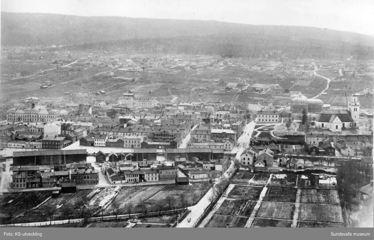 Sundsvall före branden 1888. Norrmalm och det centrala Sundsvall  i förgrunden. Vretarna upp mot Stenhammaren i bakgrunden. Sundsvallsbanken och Läroverket under uppbyggnad. Till höger i bild ses den gamla kyrkan Lovisa Ulrika.