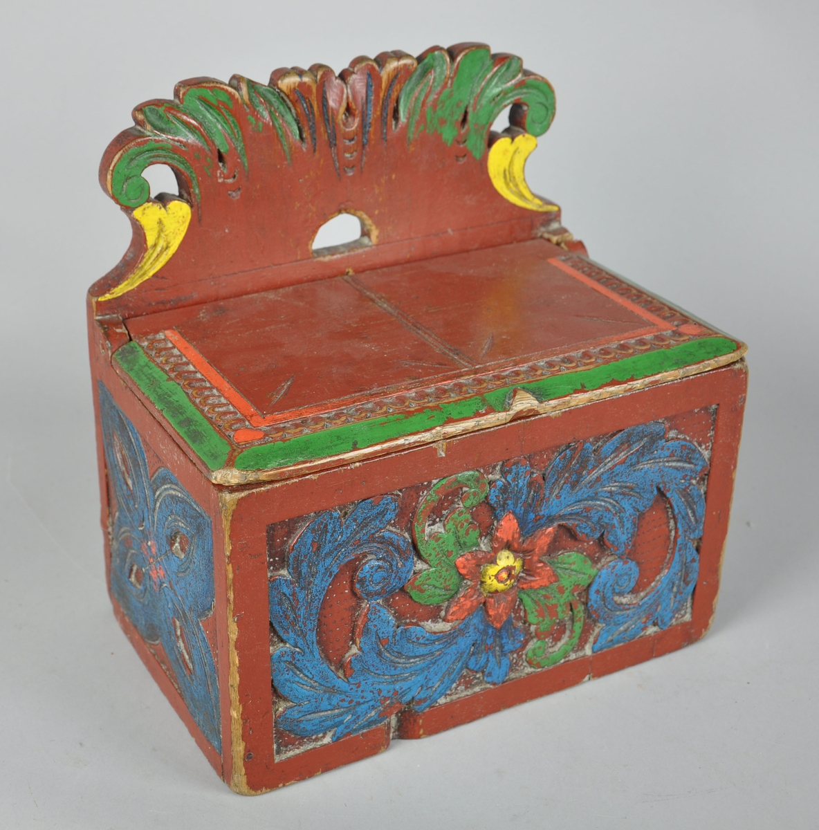 Saltkar av tre, med treutskjæringer. Saltkaret har en opphøyd bakplate med utskjærte bladmotiv og hempe for oppheng. Saltkaret har et lokk, men lokkfestet til høyre er ødelagt. Lokket har dekorative treskjæringer i motiv av linjer og perlerader. 

Saltkaret har geometrisk flatskurd på sidene, og flatskurd på forsiden med motiv av blomst og blad. Flatskurden er malt i flere farger. Det er et lite hakk på forsiden, men dette har blitt malt over. Det er såpass sterke farger at dette muligens har blitt påsatt i senere tid.