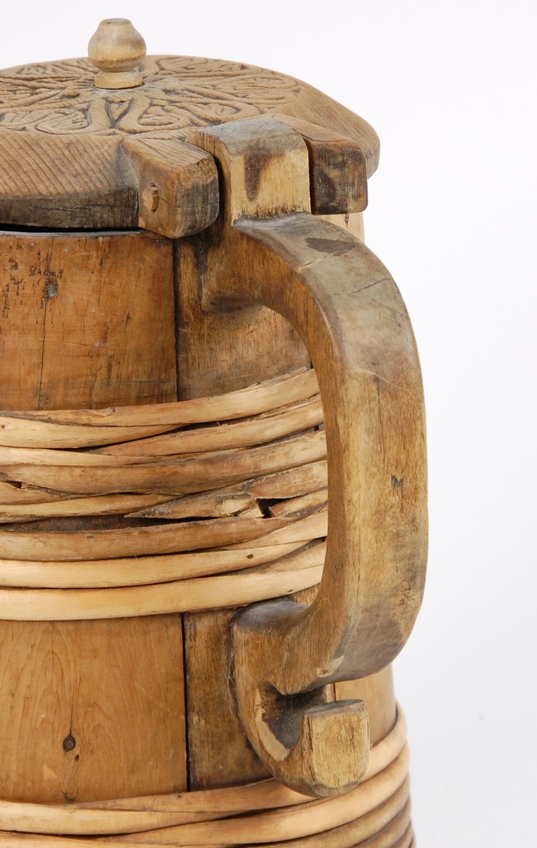 Kanne av trestaver. Lokket med seks hjerteformete utskjæringer. Lokkgrep kuleformet med flat topp. Korpus med syv gjorder oppe og åtte nede. Hanken skåret ut av en stav.