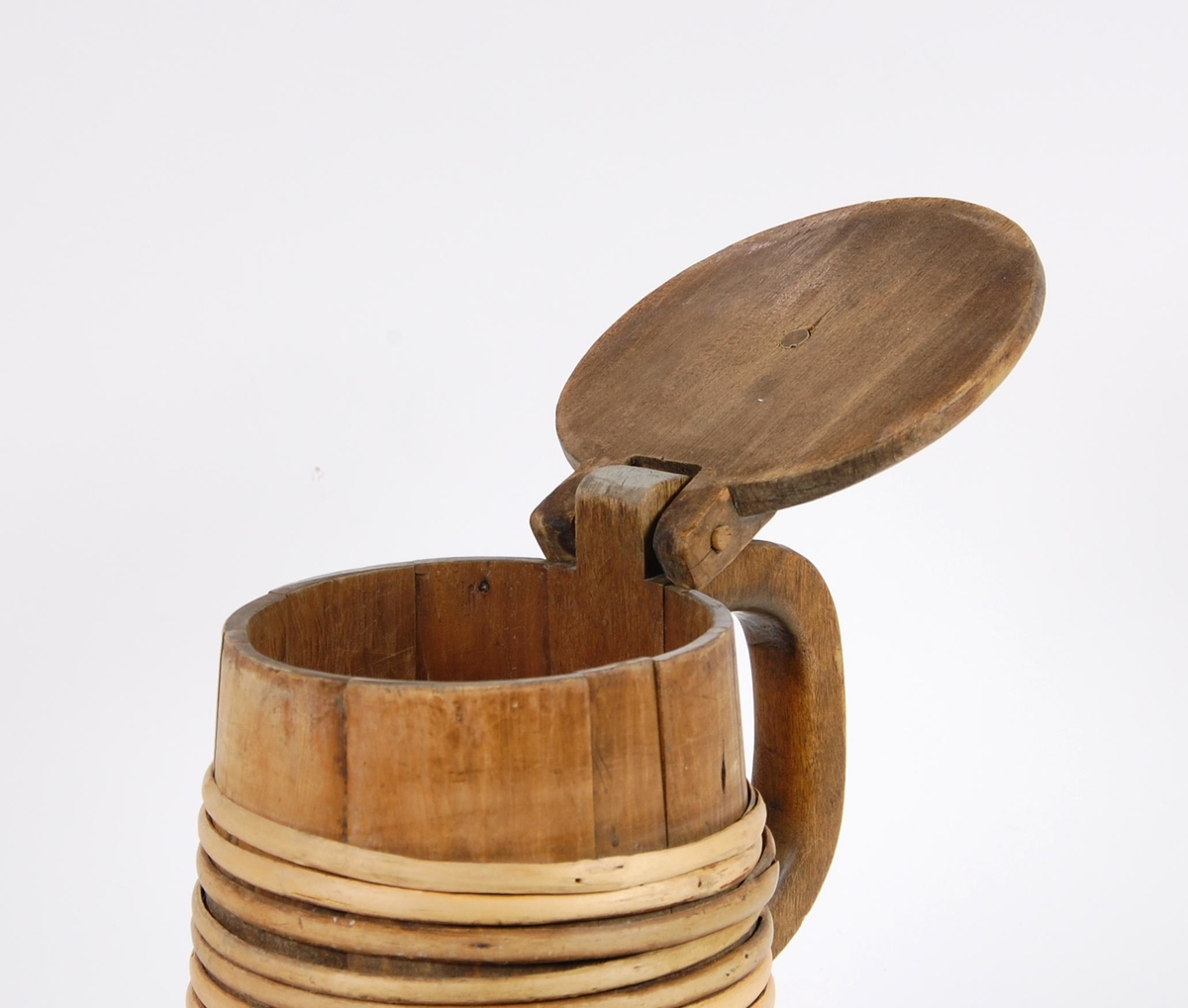 Kanne av trestaver. Lokket med seks hjerteformete utskjæringer. Lokkgrep kuleformet med flat topp. Korpus med syv gjorder oppe og åtte nede. Hanken skåret ut av en stav.