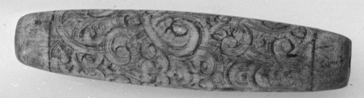 Knivskaft av tre, med sirkulære innrissinger.