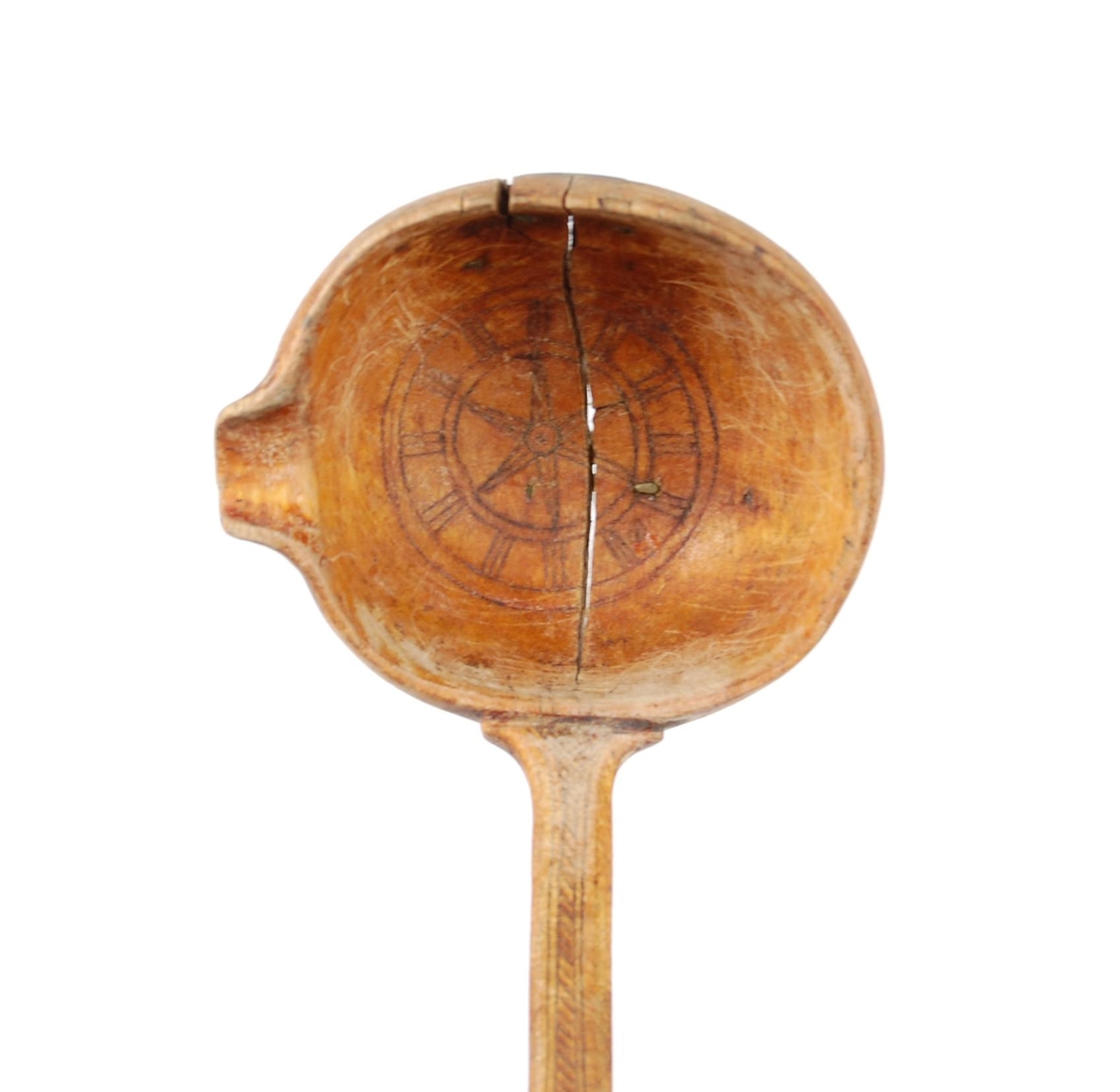 Skje av bjørk. Dypt skjeblad med nebb, i bunnen kolrosingdekor i form av bl.a. en stjerne, undersiden med kolrosingdekor i form av blader og blomster. Buet skaft med kolrosingdekor på over- og undersiden, undersiden har innskrift