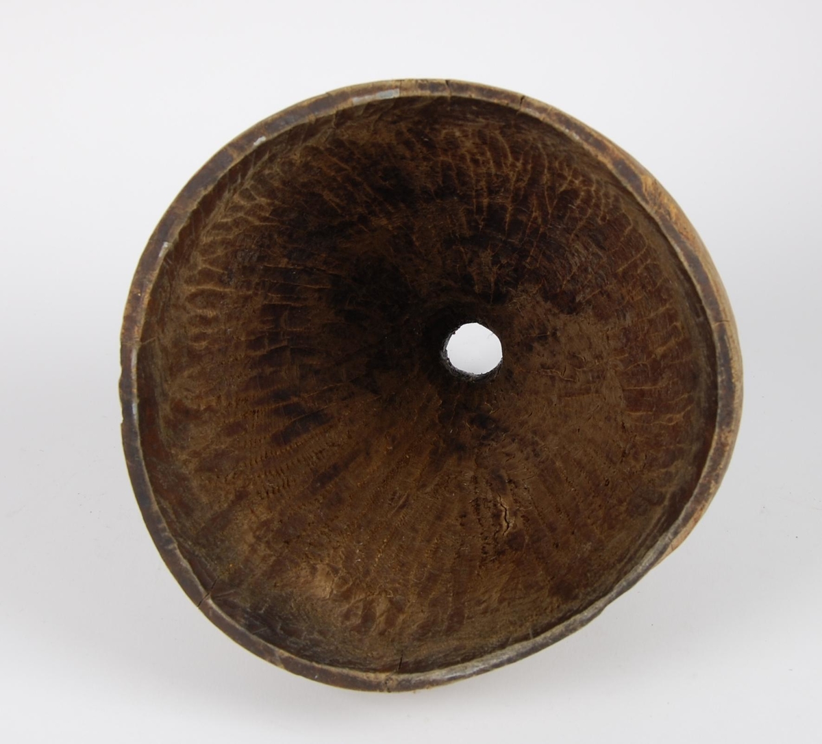 Trakt av gran. Tilnærmet rund form. Tut med rund åpning og merker etter en ring.