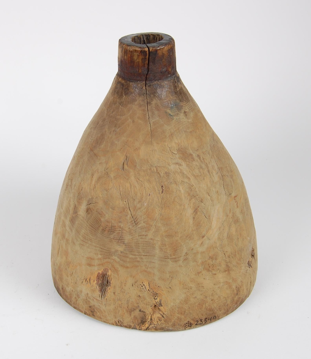 Trakt av gran. Tilnærmet rund form. Tut med rund åpning og merker etter en ring.