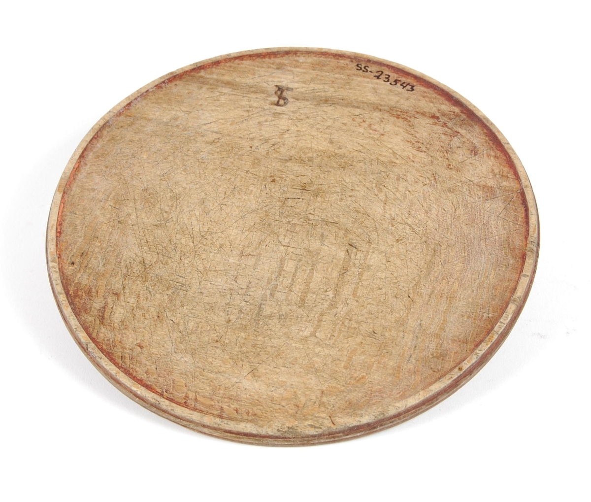 Tallerkner av dreid bøk. Sirkelrund med svak opphøyet ytterkant. Buemerke på ene siden.