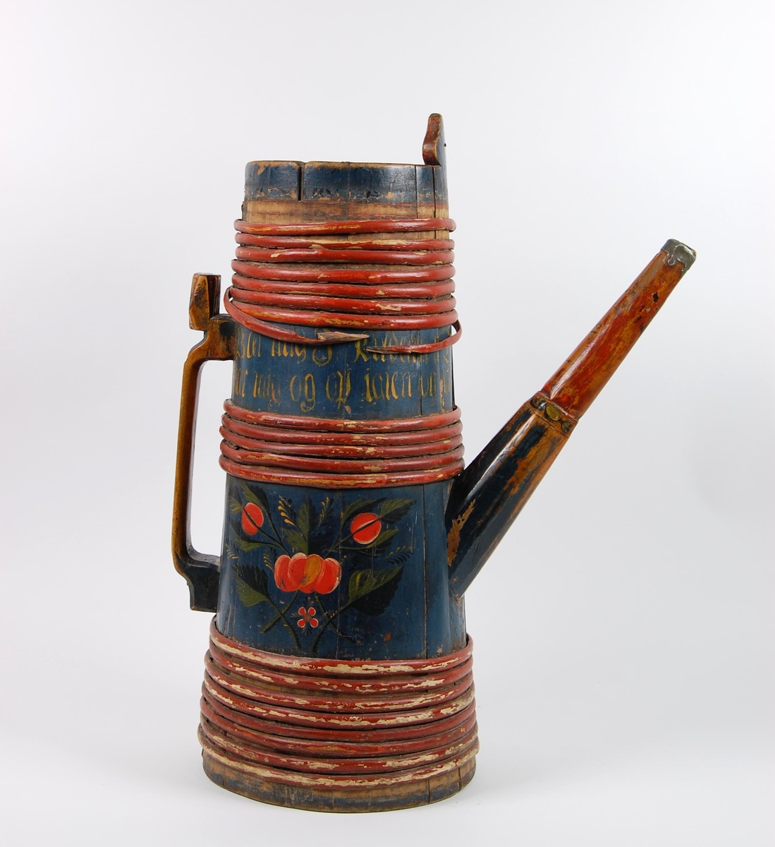 Kanne av furustaver. Fast lokk med rundt spunshull. Tuten er i ett med en av stavene som også er litt forlenget, tuten har jernbeslag ytterst. Hank er skåret ut av bakerste stav, er dekorert med akantusskurd. Korpus har åtte rødmalte gjorder øverst, fem rødmalte gjorder like over tuten og åtte rødmalte gjorder nederst, korpus dekorert med malte blad- og blomstermotiver. Lang inskrift