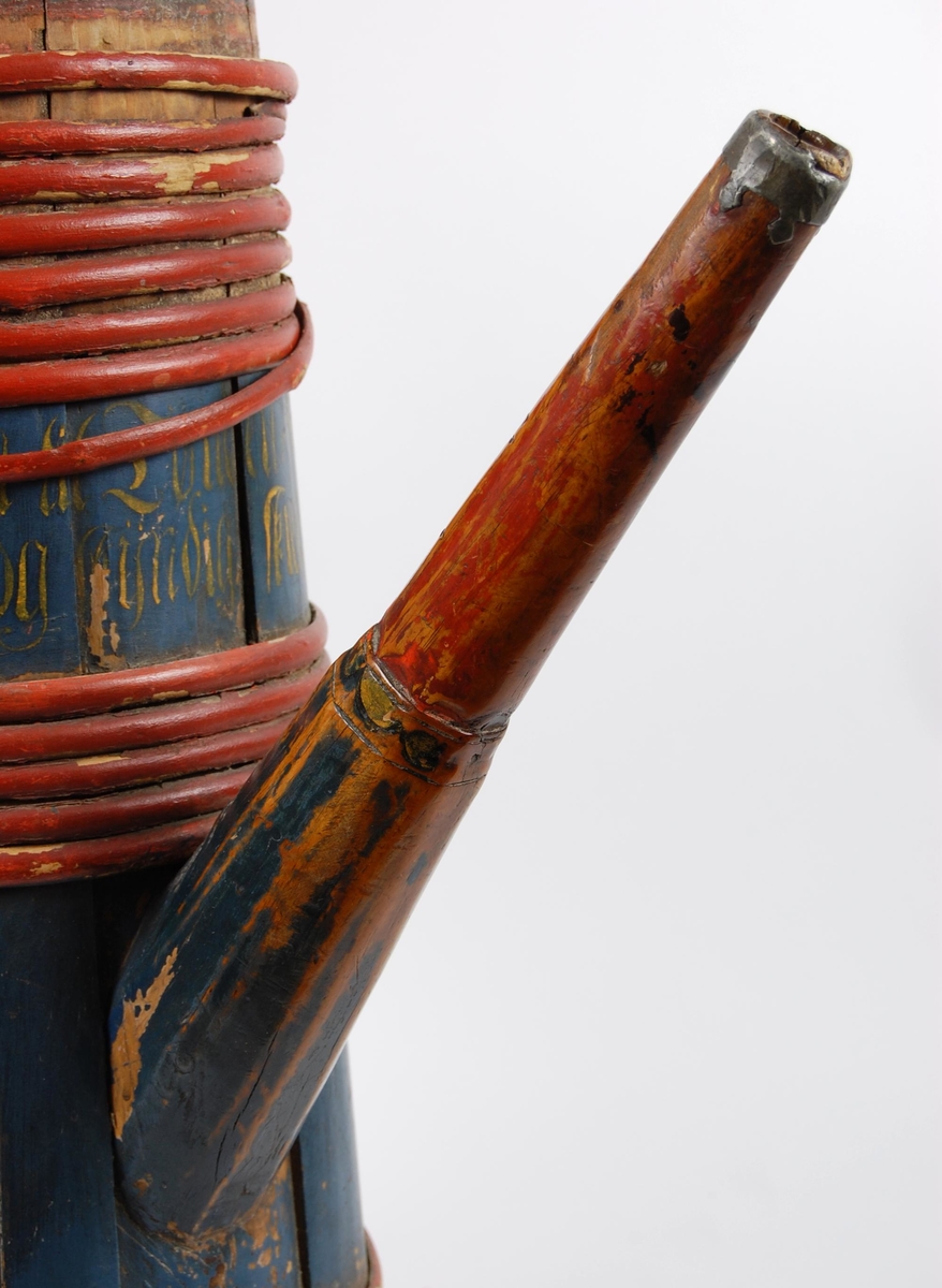 Kanne av furustaver. Fast lokk med rundt spunshull. Tuten er i ett med en av stavene som også er litt forlenget, tuten har jernbeslag ytterst. Hank er skåret ut av bakerste stav, er dekorert med akantusskurd. Korpus har åtte rødmalte gjorder øverst, fem rødmalte gjorder like over tuten og åtte rødmalte gjorder nederst, korpus dekorert med malte blad- og blomstermotiver. Lang inskrift