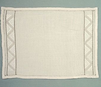 Linnetablett med broderier utförda i lingarn, broderierna är placerade i var sida. Ursprungstabletten hade dock endast broderi i ena sidan.1120:90-92 Beskrivning.