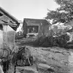 Miljö med sjöbodar, håmmor och mjärde på Gräsmarö i Gryts skärgård. I bakgrunden skymtar arrendatorbostaden till Gräsmarö 1:2. Dokumentation av Östergötlands museum 1946.
