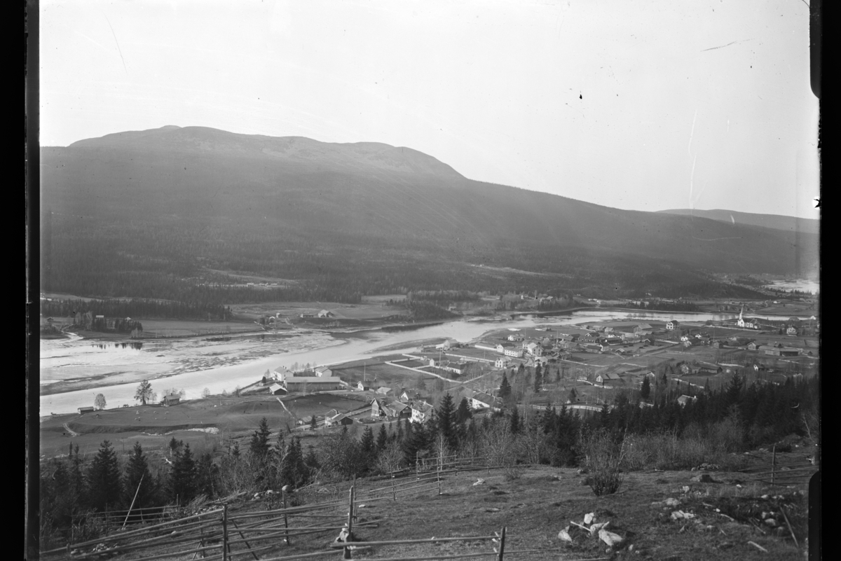 Fra Åsheim-Innbygda.
Bildet er tatt fra Bygderberget, mot Innbygda sentrum, med Trysilelva og Trysilfjellet i bakgrunnen. Tomme hesjer i forgrunnen.