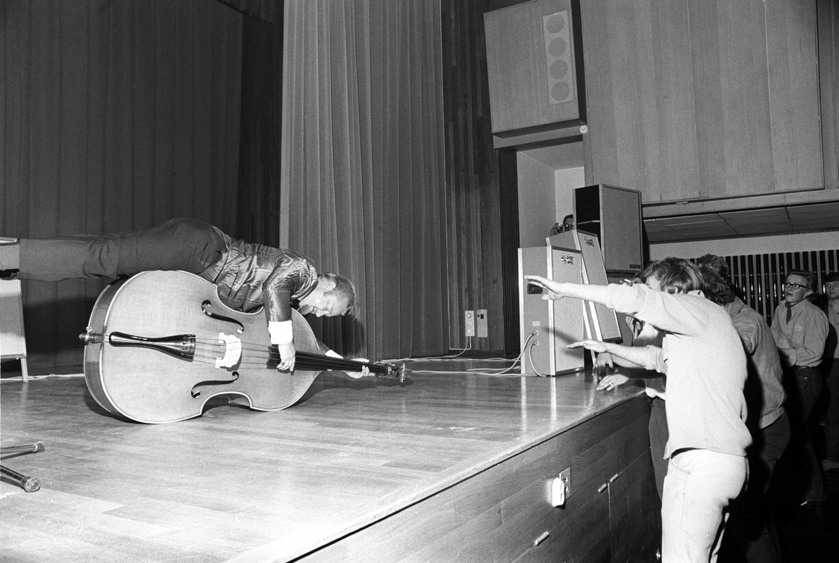 Konsert med rockens konge "Bill Haley and His Comets" i Folkets Hus i Oslo. Størst lykke gjorde denne mannnen i bandet. Ungdom følger musikken foran scenen.