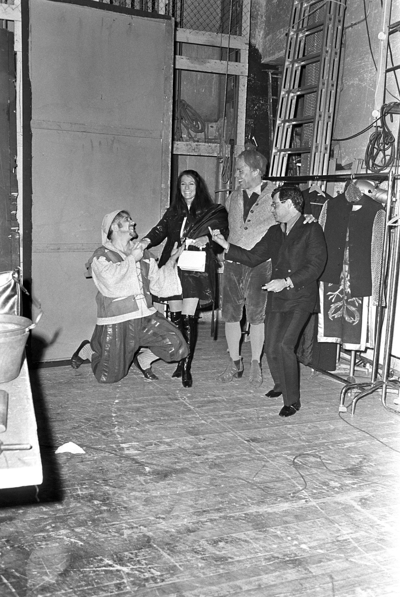 Sanger og skuespiller Eddie Fisher besøker Norge sammen med sin norske forlovede Ida Bjørn-Hansen. Etter forestillingen "Mannen fra La Mancha" på Det Norske Teatret,
hilser de på Rolf Just Nilsen til venstre og Lasse Kolstad i midten bak scenen.