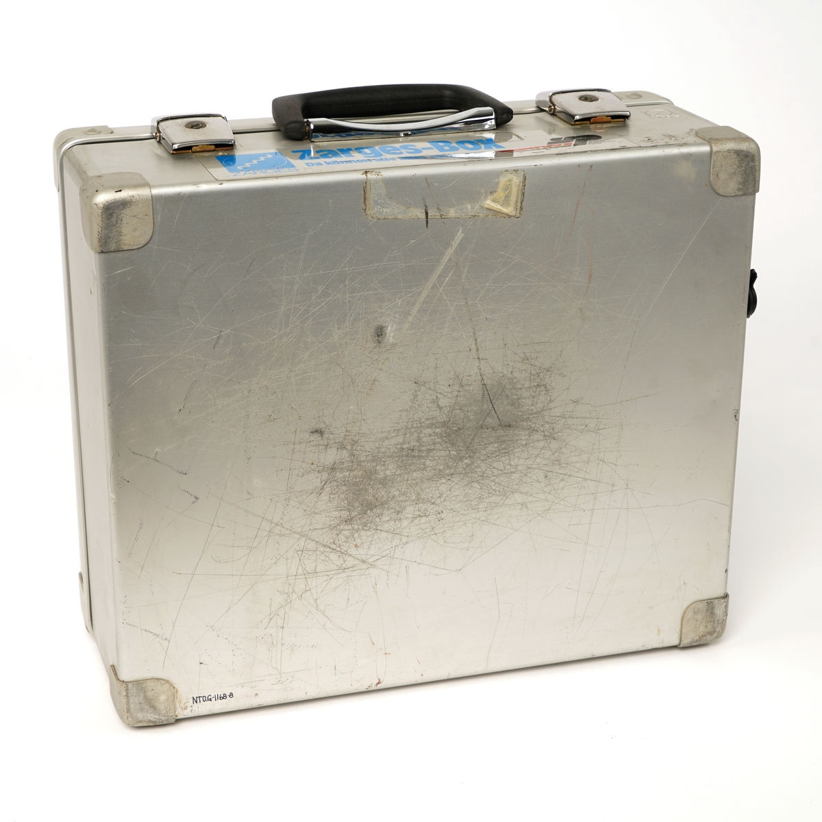 Koffert av metall belagt innvendig med skumgummi, låsbart lokk ,håndtak og  inneholdene et mobiltelefon  håndsett som er  festet til en holder . Håndsettet har et vindu på toppen og under dette er det diverse gummierte funksjonstaster og talltaster. lHolderen er igjen festet til en gjenget skillevegg og under denne finner man en en strømforsyningsenhet og mobiltelefonens hovedenhet. Videre finnes en antenne med kabel og magnetfot til å sette på eks. et biltak. Det medfølger en 240 volts strømkabel samt to 12 volts kabler med kontakter som er tilpasset et 12 volts uttak i en bil.Kofferten har et 240 volts og 12 volts uttak på siden.