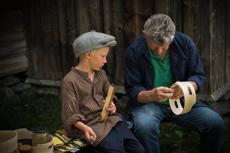 En gutt og en  mann som driver med trearbeid