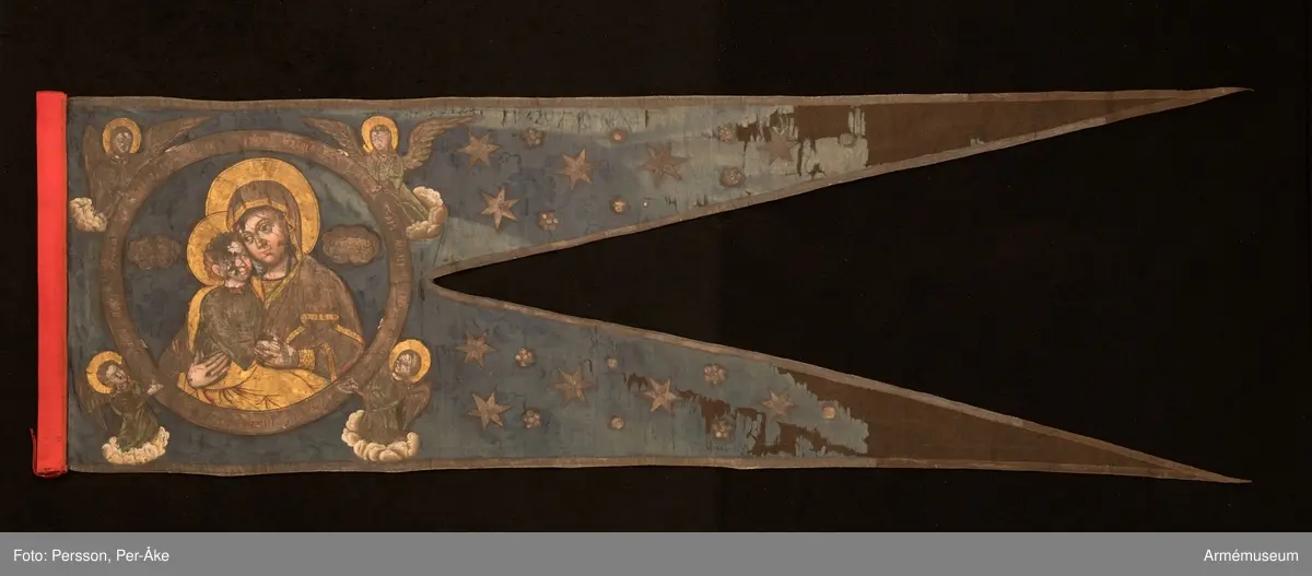 Tvåtungad duk av blå kinesisk sidendamast. Strumpa av rött kläde. Motivet målat med guld- och silverfärg.
Maria och Jesusbarnet återges i den komposition som kallas "Ömhetens Gudsmoder". Den av änglar burna medaljongen pryds av rysk inskrift som i översättning lyder: "Över dig, Fader, gläds var skapad varelse, änglarnas skara och människosläktet. Du ger ljus åt de rättrognas kyrka. Vi, dina barn, lovsjunga dig, milde Fader."
Motivet är lika på båda sidor men av stilen att döma är de målade av olika konstnärer.