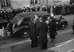 Kung Gustav V och kronprinsessan Louise anländer till högtidsgudstjänst i Uppsala domkyrka, tas emot av ärkebiskop Erling Eidem