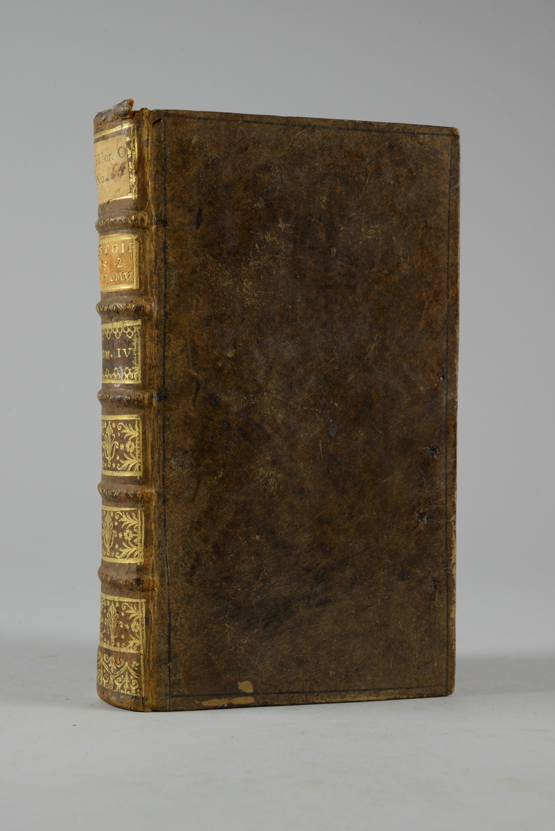 Bok, helfranskt band "Histoire des deux triumvirats" del 4, tryckt i Amsterdam 1720.
Skinnband med blindpressad och guldornerad rygg i fem upphöjda bind, titelfält med blindpressad titel, fält med volymens nummer och påklistrad pappersetikett. Med rödstänkt snitt och marmorerat papper på pärmarnas insidor.