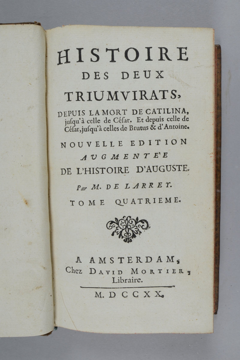 Bok, helfranskt band "Histoire des deux triumvirats" del 4, tryckt i Amsterdam 1720.
Skinnband med blindpressad och guldornerad rygg i fem upphöjda bind, titelfält med blindpressad titel, fält med volymens nummer och påklistrad pappersetikett. Med rödstänkt snitt och marmorerat papper på pärmarnas insidor.