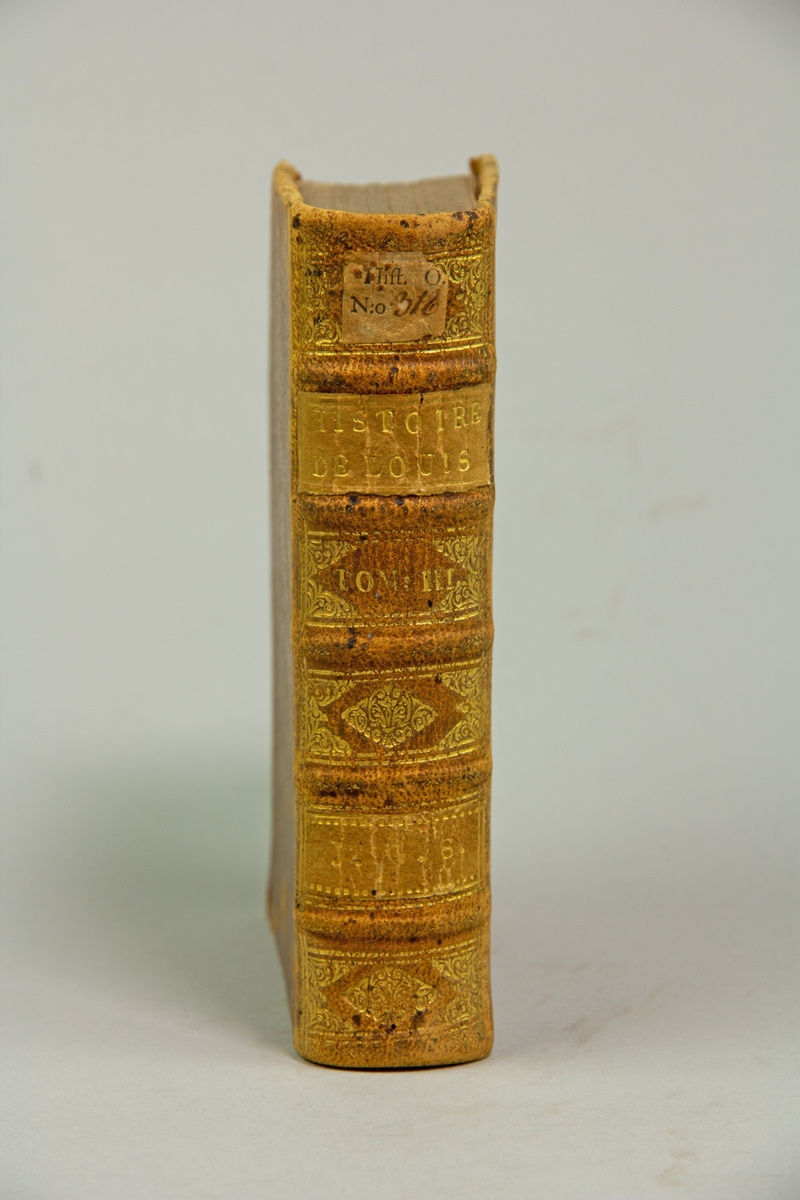 Bok, helfranskt band "Histoire de France sous le regne de Louis XIV",del III, skriven av de Larrey, tryckt i Rotterdam hos Michel Bohm & Compagnie, 1721.
Skinnband med blindpressad och guldornerad rygg i fem upphöjda bind, titelfält med blindpressad titel , fält med volymens nummer och ett fält med ägarens initialer samt påklistrad pappersetikett. Med stänkt snitt.