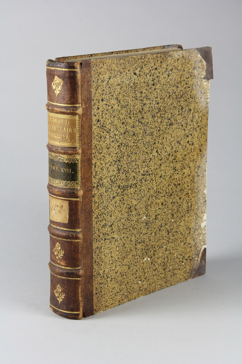 Bok, halvfranskt band "Le grand vocabulaire francois ... par une société de gens de lettres", del 17, utgiven i Paris 1771.
Band med pärmar av papp med påklistrat stänkt papper, hörn och rygg av skinn med fem upphöjda bind med guldpräglad dekor, titelfält med blindpressad titel och ett mörkare fält med volymens nummer. Med stänkt snitt. Påklistrad etikett märkt med bläck "No 2."