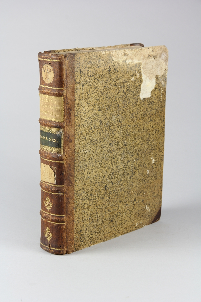 Bok, halvfranskt band "Le grand vocabulaire francois", del 30, utgiven i Paris 1774.
Band med pärmar av papp med påklistrat stänkt papper, hörn och rygg av skinn med fem upphöjda bind med guldpräglad dekor, titelfält med blindpressad titel och ett mörkare fält med volymens nummer. Med stänkt snitt. Påklistrade etiketter märkta  med bläck.