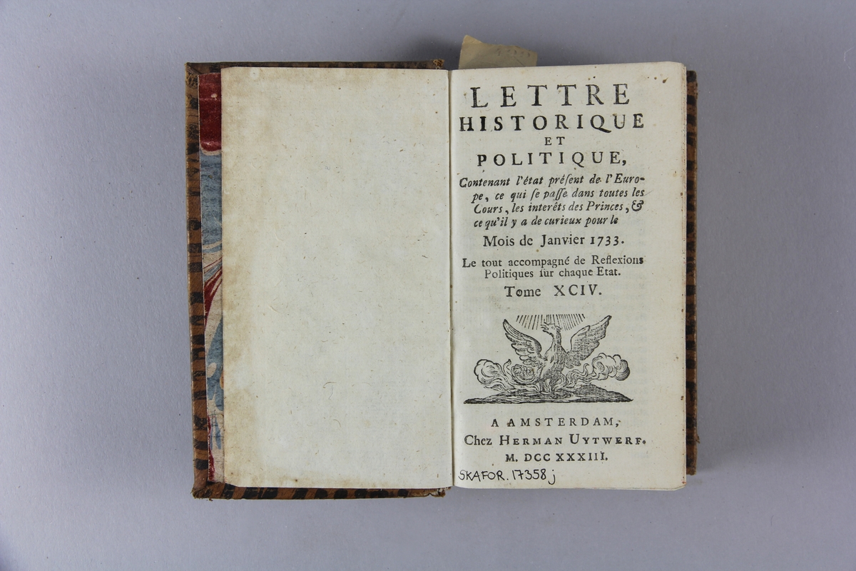 Bok, helfranskt band, "Lettre historique et politique" del 94, tryckt 1733 i Amsterdam.
Skinnband med blindpressad och guldornerad rygg i fyra upphöjda bind, skadade fält med titel, volymnummer och ägarinitialer, pappersetikett med samlingsnummer. Rödstänkt snitt.