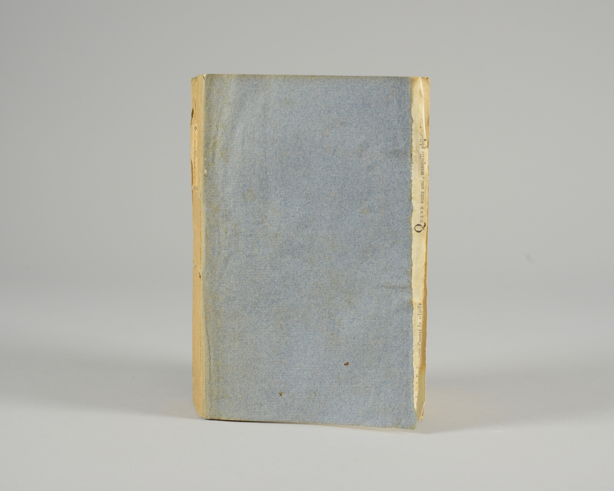 Bok, pappband,"Oeuvres completes de Voltaire", del 31 "Philosophie de Newton", tryckt 1785.
Pärmen klädd med gråblått papper, på pärmarnas insidor klistrade sior ur annan bok. Med skurna snitt. På ryggen klistrad pappersetikett med tryckt text samt volymens nummer. Ryggen blekt. Med planscher.