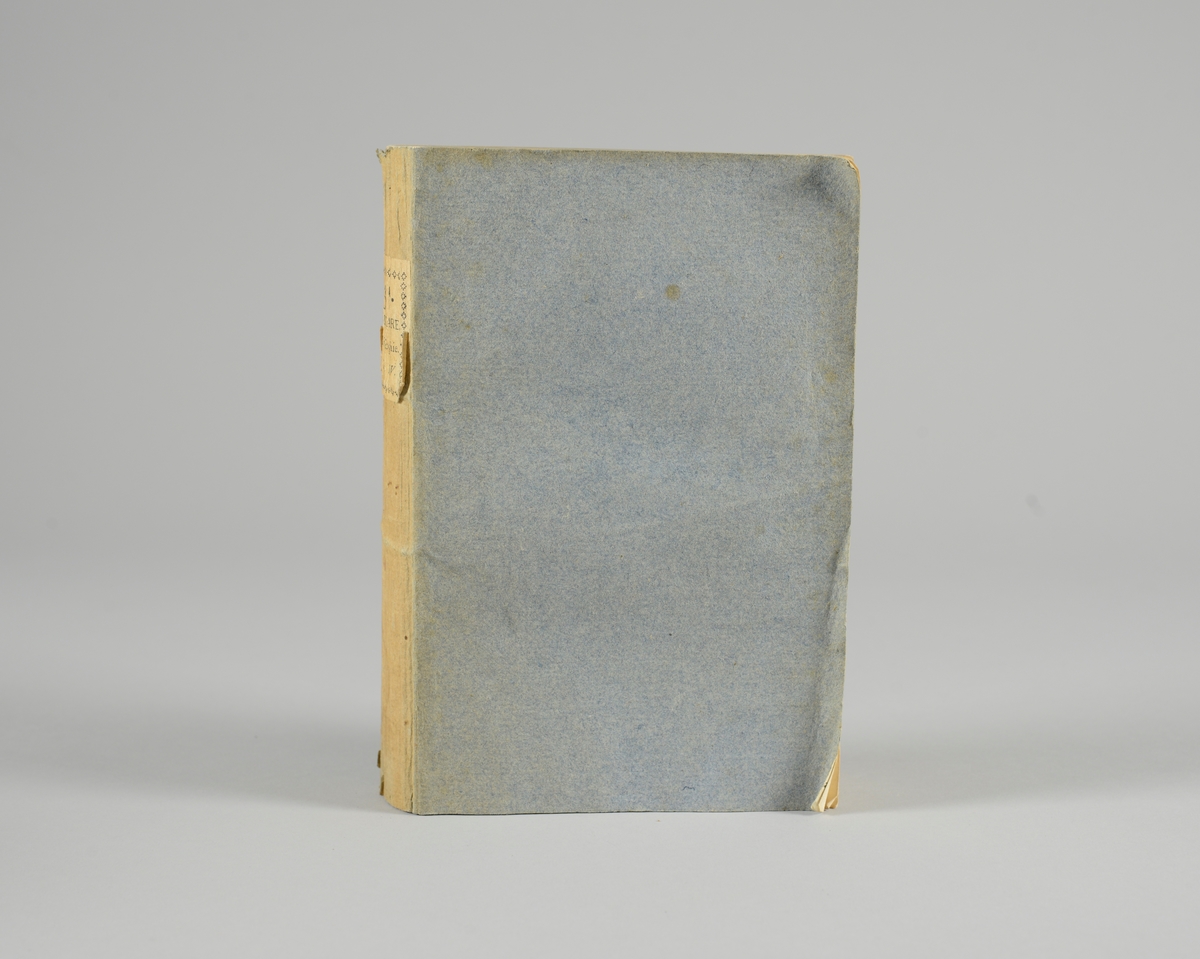 Bok, pappband,"Oeuvres completes de Voltaire", del 35, tryckt1785.
Pärmen klädd med gråblått papper, på pärmarnas insidor klistrade sidor ur annan bok. Med skurna snitt. På ryggen klistrad pappersetikett med tryckt text samt volymens nummer. Ryggen blekt.