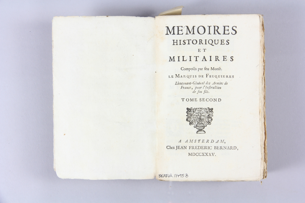 Bok, pappband, "Mémoires historiques et militaires", del 2, tryckt 1735 i Amsterdam. Pärmar av marmorerat papper, blekt rygg med etikett med volymens namn (oläsligt) och samlingsnummer. Oskuret snitt, ej uppskuren.