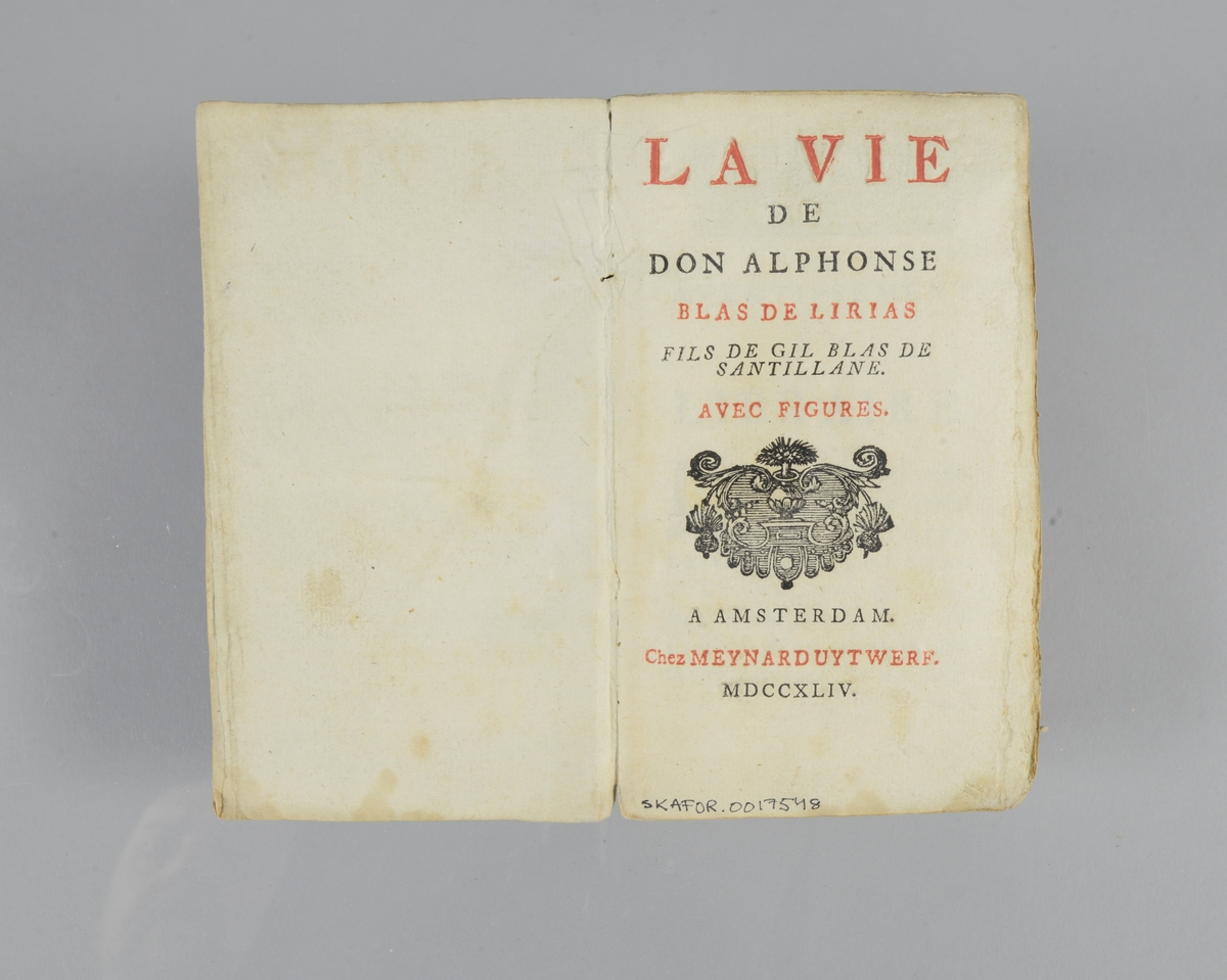 Bok, häftad,"La vie de don Alphonse Blas de Lirias", tryckt 1744 i Amsterdam. Marmorerade pärmar, blekt rygg med etikett med bokens titel och nummer. Oskuret snitt.