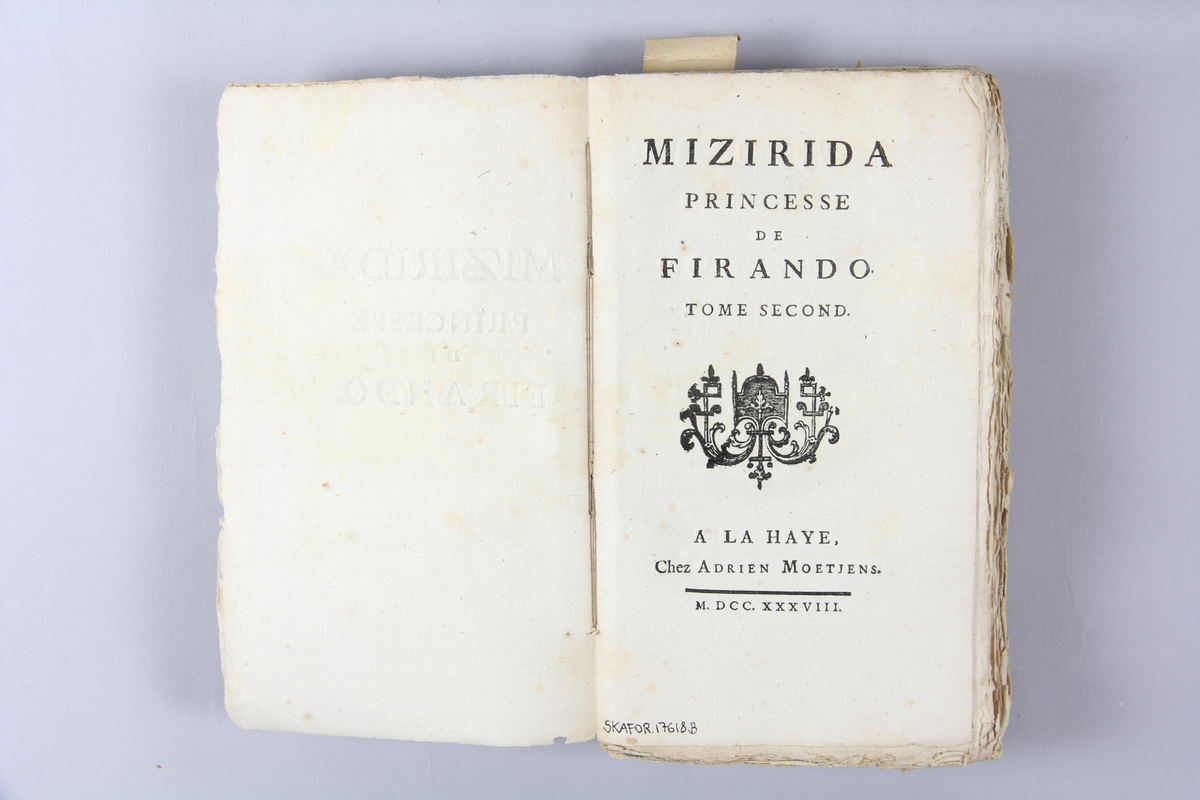 Bok, häftad, "Mizirida, princesse de Firando", del 2, tryckt 1738 i Haag.
Pärm av marmorerat papper, oskuret snitt.  Blekt rygg med pappersetikett med volymens namn och samlingsnummer.