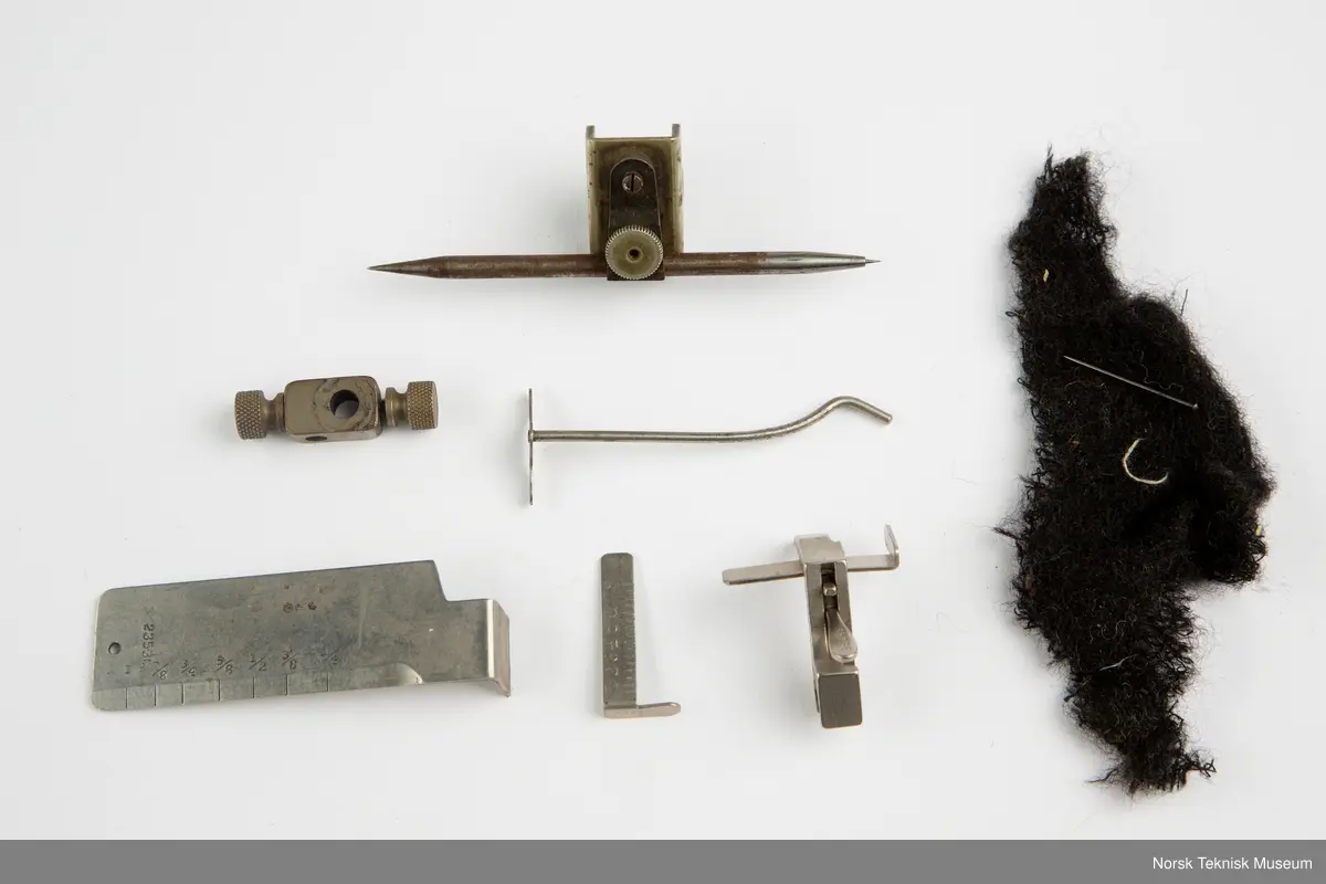 Lokket mangler. Inneholder oljekanne, verktøy, nåler, spoler, rem, symaskinfot, trådsnelle.