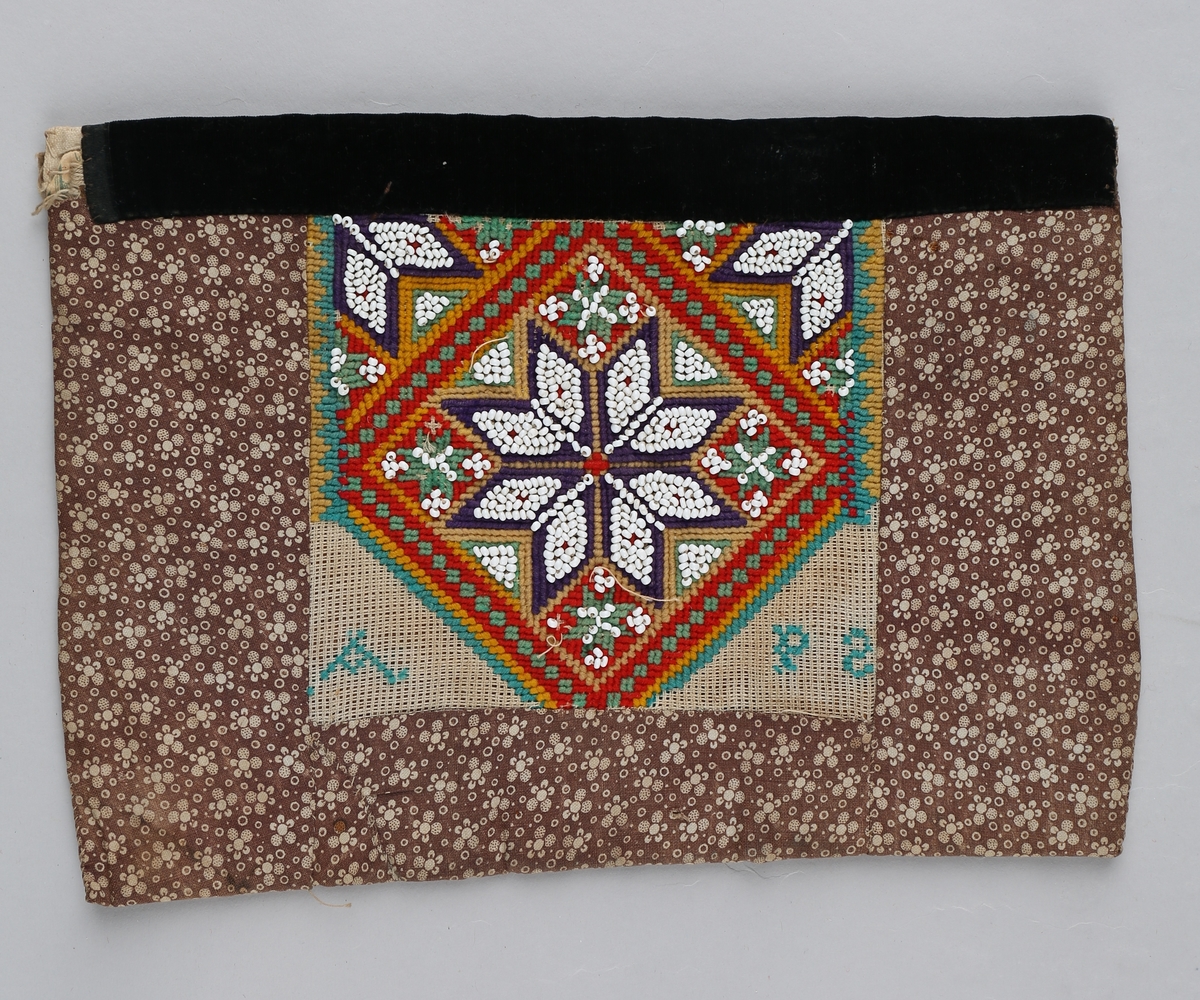 Hovedmotivet er ei åttebladrose i perlebroderi med to 1/4 dels åttebladroser (perlebroderi) oppe i kvart hjøre innenfor ein firkant. Resten av dekoren er broderi med tråd med litt perler inni mellom. Nederst i firkantens venstre hjørne er det brodert en A og nederst i høgre hjørne er det en P og en omvendt S.