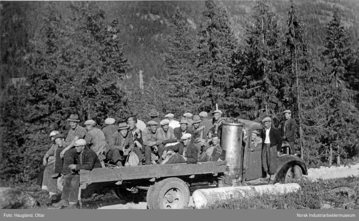 Arbeidslag på Tuddalsdalen, Sauland. Lastebil med vedgassgenerator, lastebilden tilhører Ingebret Brennekåsa. Persontransport på lasteplan, i forbindelse med utbyggingen av kraftlinje fra Dale til Herøya (Knardalstrandlinjen/Tyskerlinja).